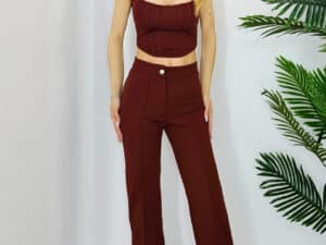 Set complet elegant maro cu top cu decolteu simetric și pantaloni evazați, perfect pentru ocazii spe.