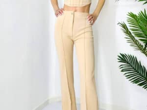 Compleu crem cu decolteu simetric, cusături evidențiate, pantaloni evazați, stil sofisticat.